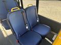 Two blue passenger seats with yellow grab handles in the interior of a 2017 Ford Transit-350