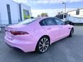 A 2020 Jaguar XE painted entirely in pink with a sleek design featuring a distinctive rear light arrangement and sporty alloy wheels