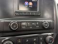 Controls and display interface of a 2016 GMC Sierra 1500 featuring buttons for audio settings radio media and air conditioning