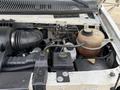 Engine compartment of a 2002 Ford Econoline showing various components including the air intake hose coolant reservoir and power steering fluid container