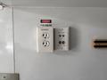 A wall-mounted electrical outlet featuring two standard sockets a USB port and a warning label indicating 115 volts with the word "Danger" above it