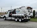 A 2013 International Workstar 7500 vacuum truck with a large tank and hoses attached to the rear for waste removal operations