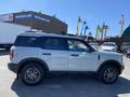 A 2023 Ford Bronco Sport in a light color with a sleek design and alloy wheels parked to the side