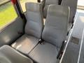 Two gray seats with vertical stripes and seatbelts in a school bus setting