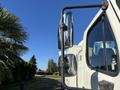 A 2006 Freightliner M2 106 truck with a prominent side mirror and clear cab visibility