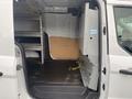 A 2017 Ford Transit Connect with an open sliding door revealing a spacious interior featuring shelving and a partition wall