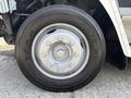Close-up of a Goodyear tire mounted on a silver wheel of a 2011 Workhorse W62 displaying eight lug nuts and clear tread pattern