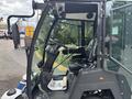 A 2019 Madvac LS175 street-sweeping vehicle featuring a large front window a steering wheel and control levers inside the cabin