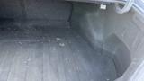 The image shows the empty trunk of a 2018 Hyundai Sonata with a dark carpeted interior and some debris on the floor