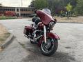 A 2009 Harley-Davidson Road King motorcycle in a deep red color features a large front fairing and saddle bags with chrome accents and a classic design