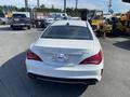 A white 2014 Mercedes-Benz CLA-Class viewed from the rear showcasing its sleek design and distinctive taillights
