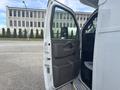 A 2020 Chevrolet Express van with an open driver side door revealing the interior features and controls