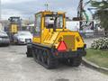 A yellow 2004 Bombardier SW48 utility vehicle with tracks and a glass cabin designed for snow removal and utility work