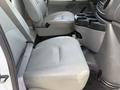 A 2008 Ford Econoline interior featuring two leather seats side by side with a cup holder console between them
