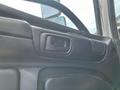 Interior view of a door handle from a 2018 Hino 338 truck showing the textured black material and a side mirror in the reflection
