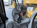 A black portable fan mounted on the dashboard of a vehicle with a red center and metal grille