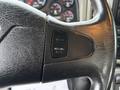 Close-up of a steering wheel with buttons for cruise control labeled "SET" and "RESUME/ACCEL" visible on the left side
