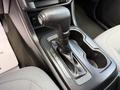 The gear shift of a 2018 Chevrolet Colorado with a black lever positioned in the park position and an illuminated gear indicator next to it