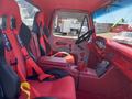 Interior of a 1962 Ford 2WHDR with red racing seats and harnesses a steering wheel and a dashboard with gauges