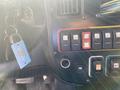 Dashboard of a 2011 Chevrolet Express with various buttons gauges and a keychain attached to the ignition