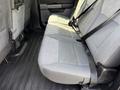 The interior back seat of a 2021 Ford F-150 with gray fabric upholstery and seat belts attached