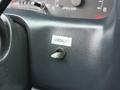A close-up of the dashboard of a 2001 Ford F-350 showing a Versalift switch with a keyhole.