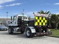A white 2016 Freightliner 108SD truck with a black and yellow checkerboard pattern on the rear and various equipment mounted on the chassis