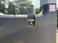 A close-up view of a yellow latch mechanism on the rear door of a 2025 Ford Transit T-350