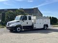 A 2006 International 4300 truck with a white exterior and a large boxy cargo area equipped with multiple compartments and a black front bumper