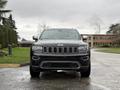 A black 2019 Jeep Grand Cherokee facing forward with a prominent front grille and headlights visible