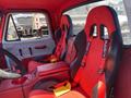 Interior of a 1962 Ford 2WHDR featuring two sporty red racing seats with harnesses and a black steering wheel