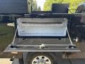 A black Ford F-350 SD pickup truck with an open storage compartment displaying a clean interior and metal support bars attached with chains
