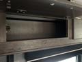 A storage compartment in a 2021 Jayco Jay Flight camper with a dark wood finish and metallic hardware