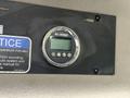 A round digital display labeled Air-Weigh attached to a surface with warning notice signs above it
