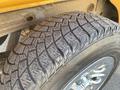 Close-up of a treaded tire from a 2013 Chevrolet Silverado 1500 showcasing detailed grooves and texture on the rubber surface