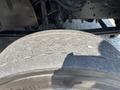 A close-up of a worn tire on a 2005 GMC C7500 Topkick showing visible tread wear and dirt accumulation