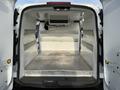 Interior view of a 2019 Ford Transit Connect cargo space with metal shelves on the sides and a flat floor