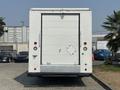 A white 2018 Ford Econoline cargo van with a large rear door and red stop lights