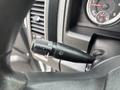 A close-up of the windshield wiper and headlight control stalk in a 2016 RAM 1500 featuring various symbols for wiper speed and light settings