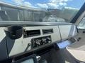 Interior dashboard of a 1997 Freightliner FL70 featuring controls ventilation knobs and a cup holder