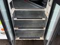 Stairs leading up into the interior of a 2009 Ford Econoline with rubber treads for grip and a clean metal edge