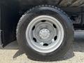 Close-up of a silver alloy wheel with a black tire labeled Radial on a 2018 Hino 195