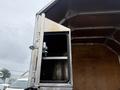 A silver 2011 Dodge Ram 5500 with an open side door revealing a storage compartment inside