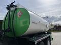 A 1996 Kenworth T800 truck with a large green and white tank attached to its back featuring safety warning labels