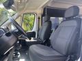 The interior cabin of a 2022 RAM Promaster 350 featuring two gray upholstered seats and a steering wheel