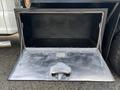 A metallic storage compartment on a 2017 Ford F-550 with a hinged door opened to reveal an empty interior