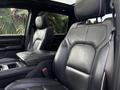 Interior view of a 2021 RAM 1500 showing black leather front seats with detailed stitching and a center console