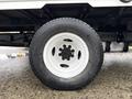 Close-up of a white wheel and tire of a 2024 Ford E-450 showcasing a black hubcap and rugged tire tread