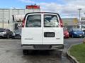 A 2023 GMC Savana van viewed from the rear with a white exterior and a blank license plate area
