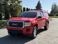 Red 2018 GMC Canyon pickup truck with a fitted canopy and ladder rack on top parked on a driveway